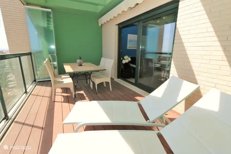 Balkon mit Sonnenliegen und Esstisch