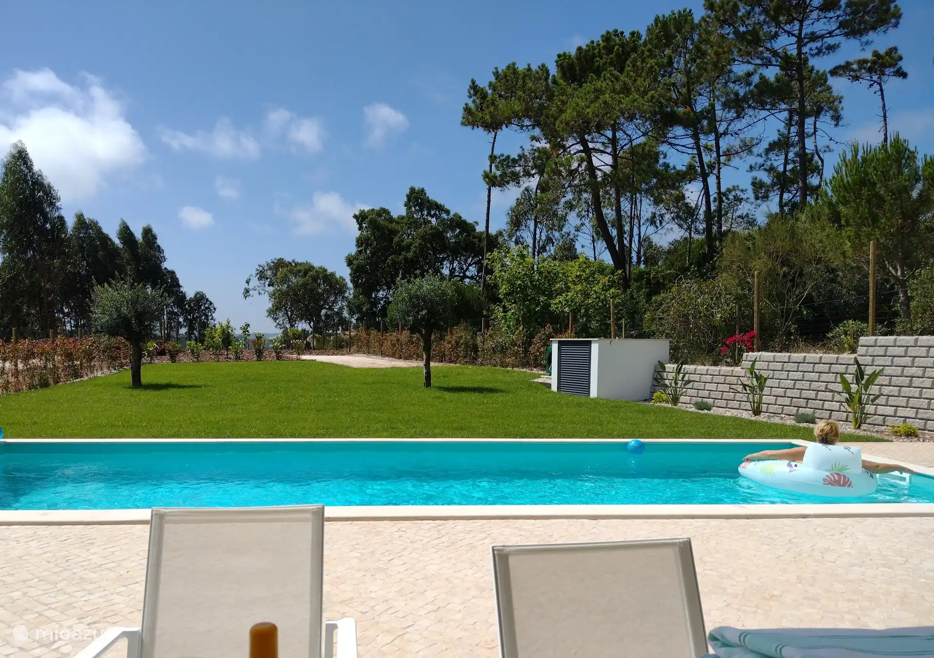 Swimmingpool mit großzügiger Terrasse und Garten