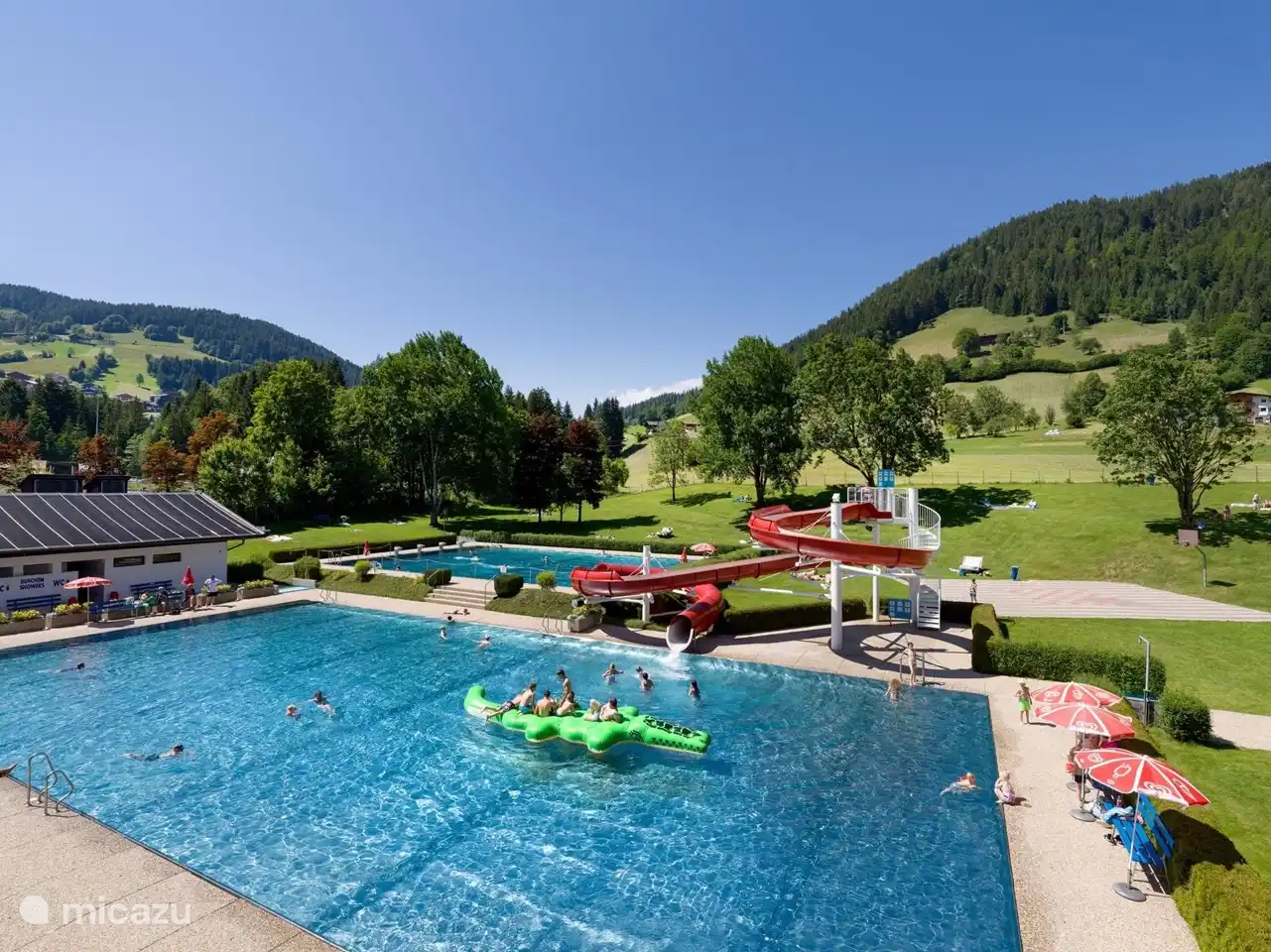 Mooi zwembad, 2 banen, glijbaan en zonnige ligweide met bergzicht.