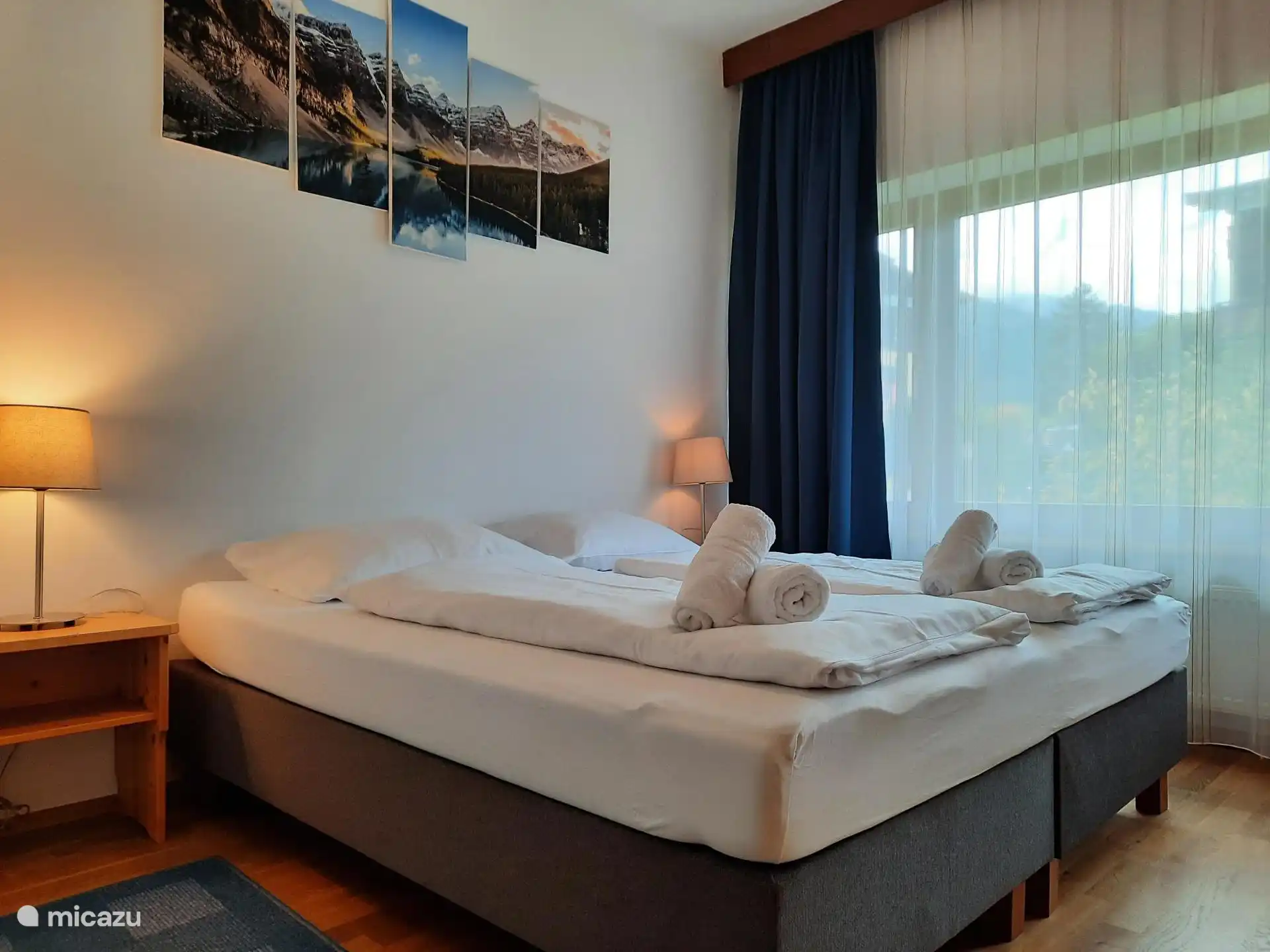 Slaapkamer 1 met een 2-persoons boxspring bed dat ook als 2x 1-persoonsbed gebruikt kan worden, nachtkastjes met verlichting, kledingkasten.