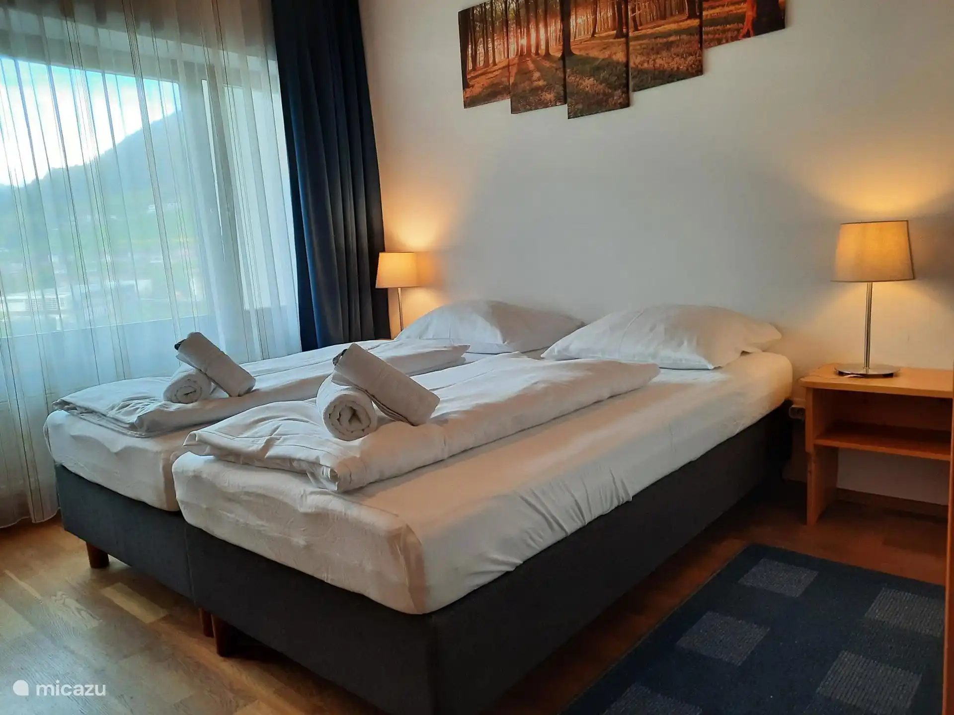 Slaapkamer 2 met een 2-persoons boxspring bed dat ook als 2x 1-persoonsbed gebruikt kan worden, nachtkastjes met verlichting, kledingkasten.
