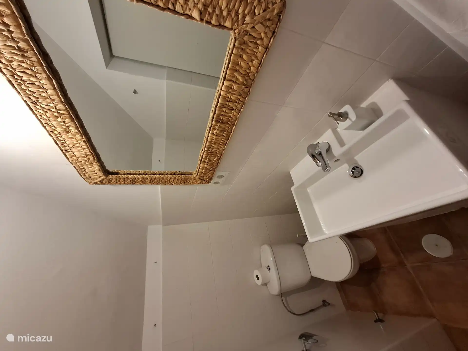 Badkamer met wastafel, toilet en doucheruimte met glazen schuifdeur