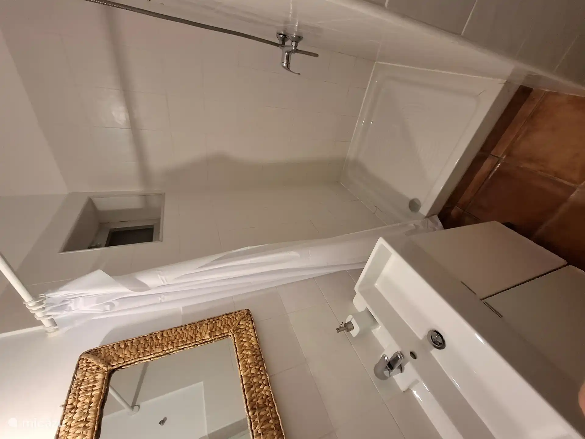 Badkamer met wastafel, toilet en doucheruimte met glazen schuifdeur