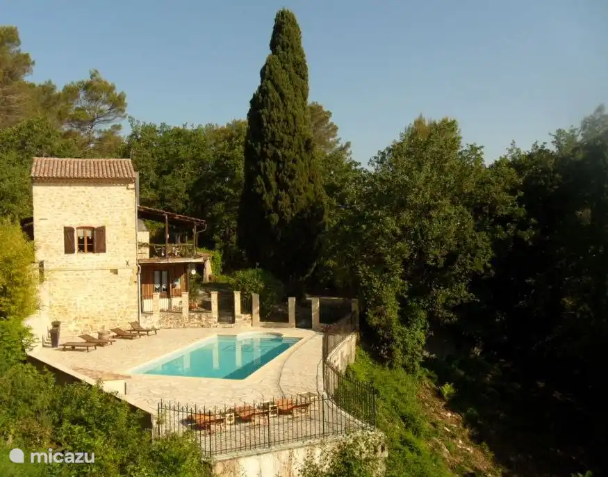 Vista exterior de la casa entre el bosque y el río