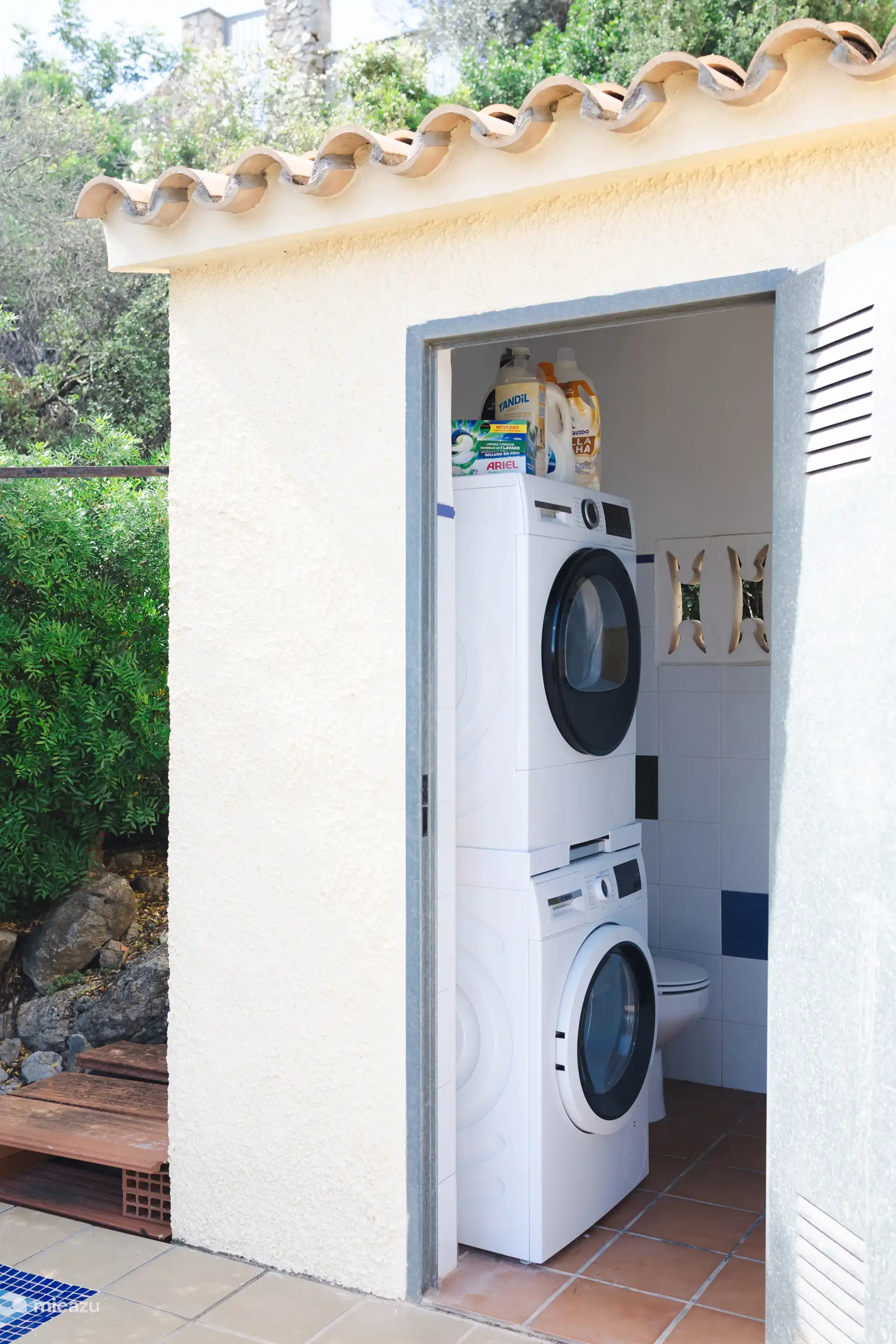 Buanderie avec machine à laver, sèche-linge et toilettes extérieures