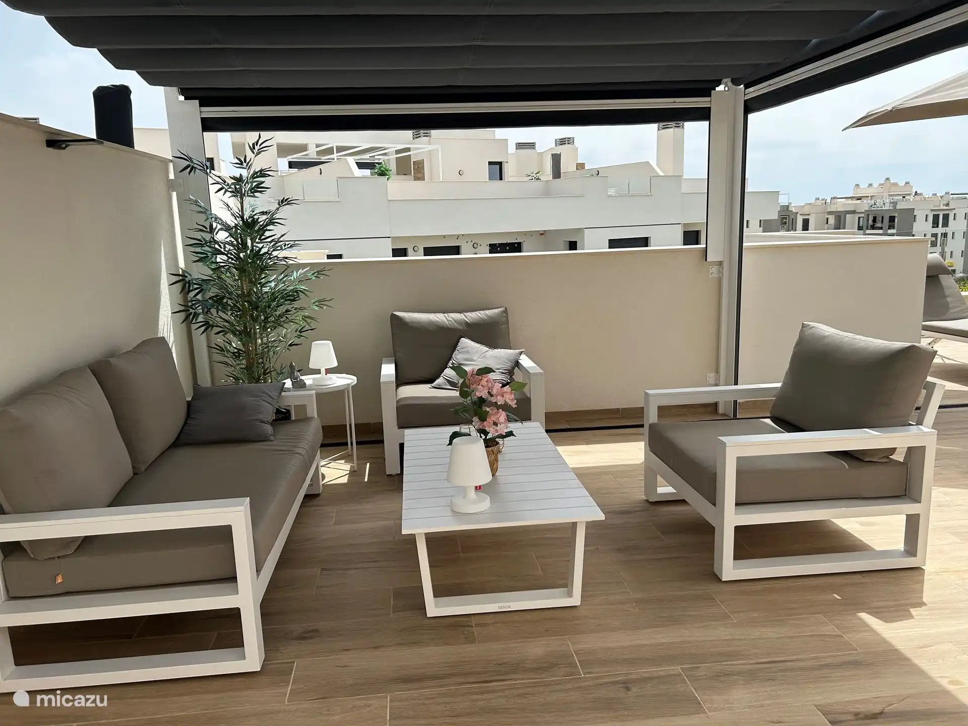 dakterras met een pergola en een loungeset