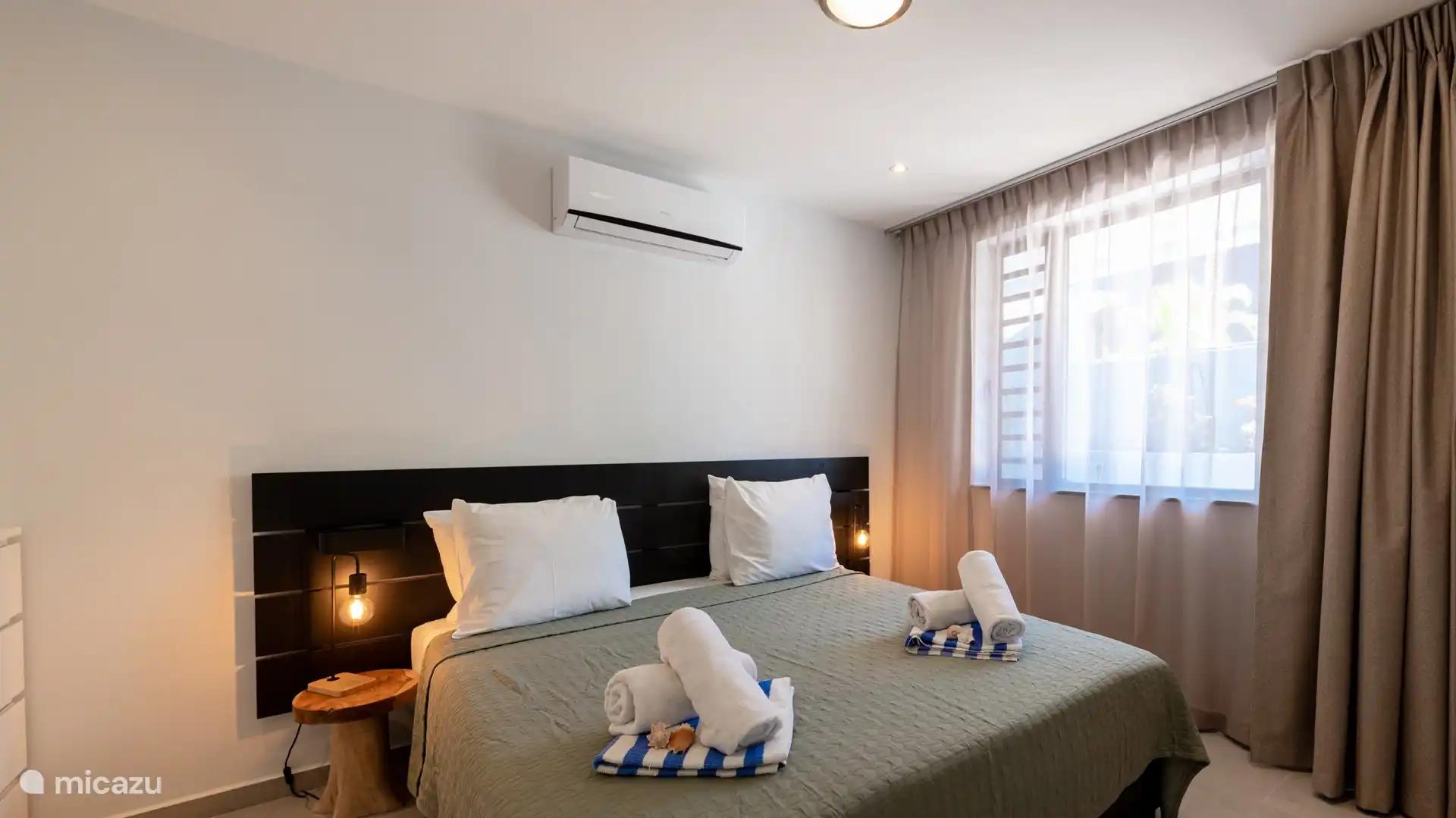 Das Schlafzimmer verfügt über Klimaanlage und Fernseher.