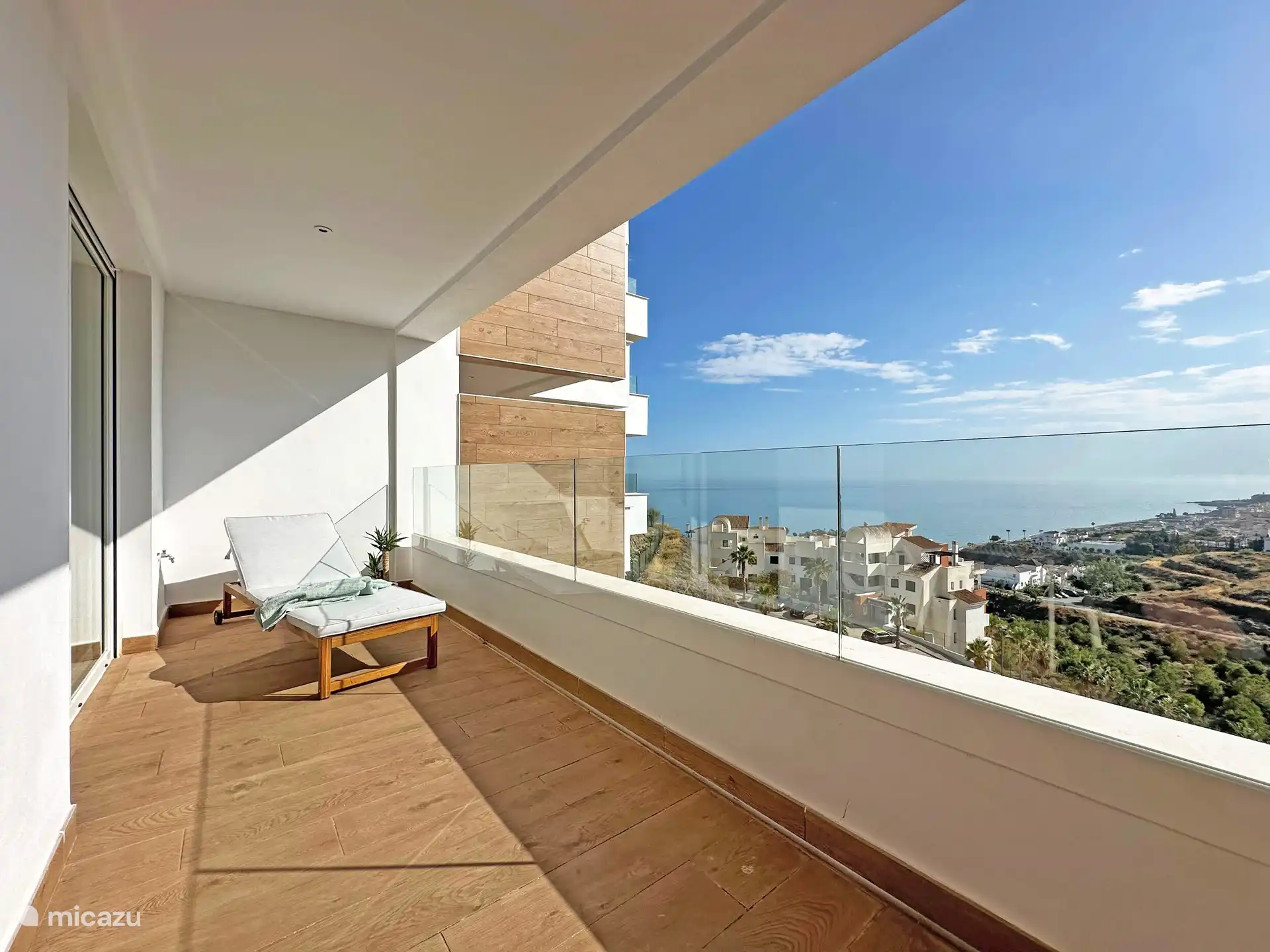 Balkon voorzien van ligbed met het uitzicht over Torrox Costa. Schuifdeur naar hoofd slaapkamer