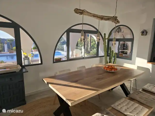 Cortijo Algarrobo en España, Costa del Sol, Torrox - villa En el jardín acristalado/comedor hay una gran mesa de comedor para al menos 8 personas. Desde el jardín de invierno hay una hermosa vista sobre la terraza, la piscina y los alrededores.