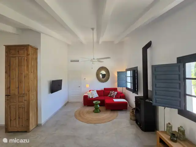 Cortijo Algarrobo en España, Costa del Sol, Torrox - villa El salón cuenta con un cómodo sofá con puf y sillón a juego, una SmartTV con Chromecast, una estufa de leña, ventilador y aire acondicionado central (regulable) (frío/calor).