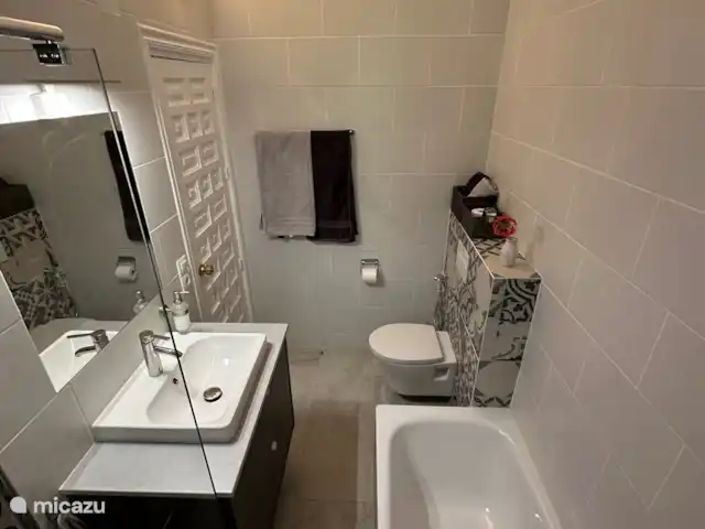 Cortijo Algarrobo en España, Costa del Sol, Torrox - villa El cuarto de baño en suite (baño 1) adyacente al dormitorio 1 tiene bañera, lavabo en muebles, ducha a ras de suelo e inodoro.