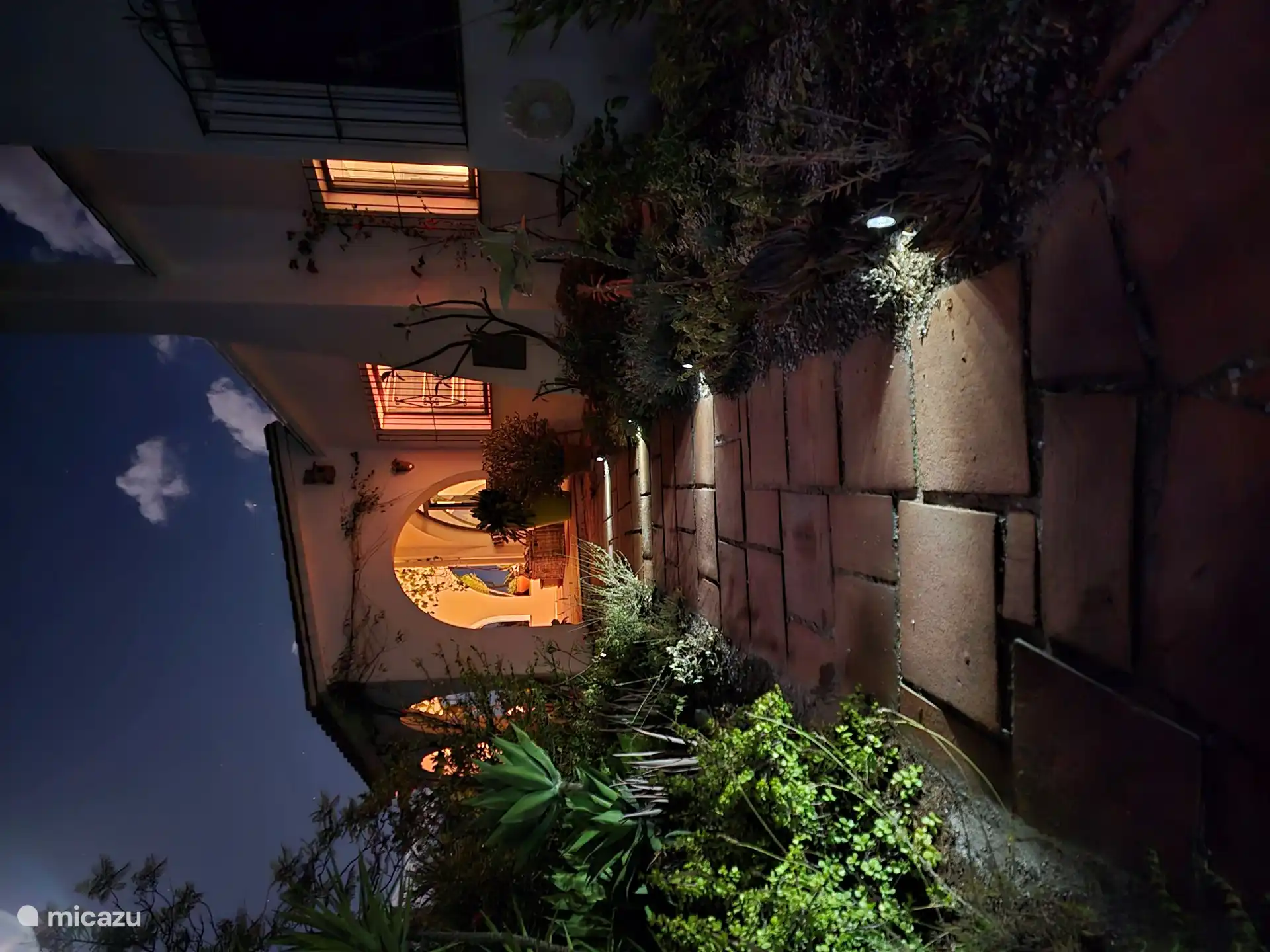 Entrada a la puerta principal en el invernadero a lo largo del sendero iluminado del jardín.