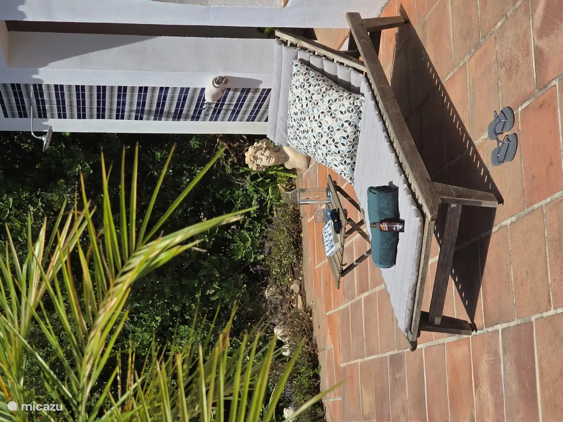 Relajar. Al fondo la ducha exterior con agua fría y caliente.