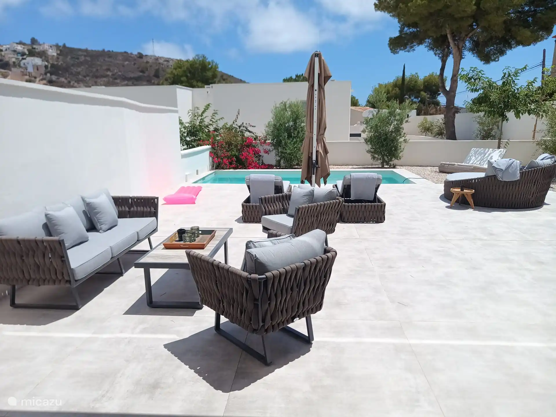 the sun terrace with lounge, sunbeds and loveseats with parasol. 
