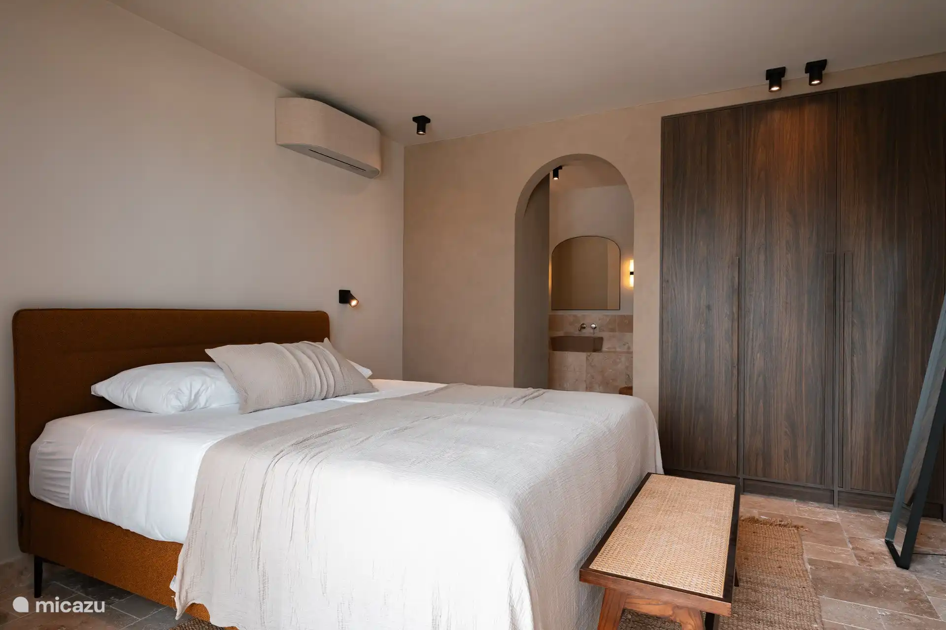 Een van de slaapkamers boven met en-suite badkamer en uitzicht op het zwembad en de tuin. 