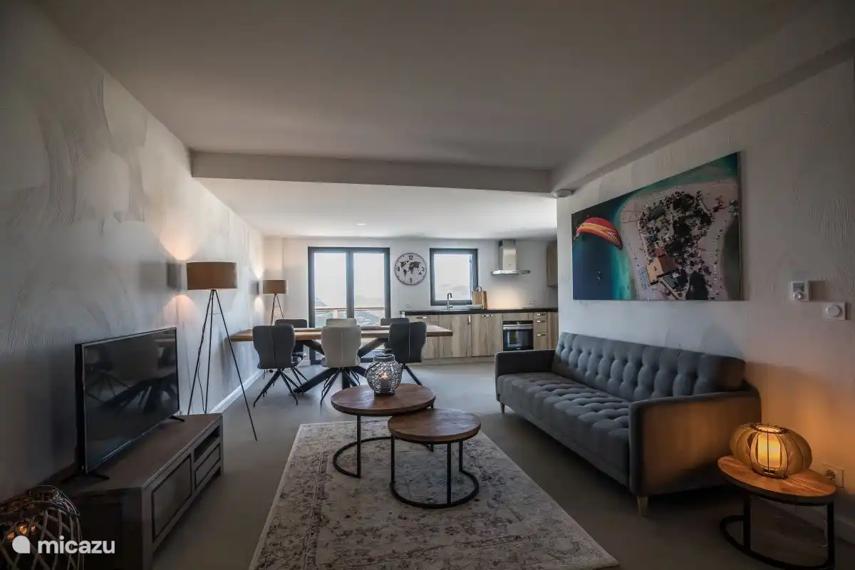 Gemütliches Wohnzimmer mit Schlafcouch und Flachbildfernseher