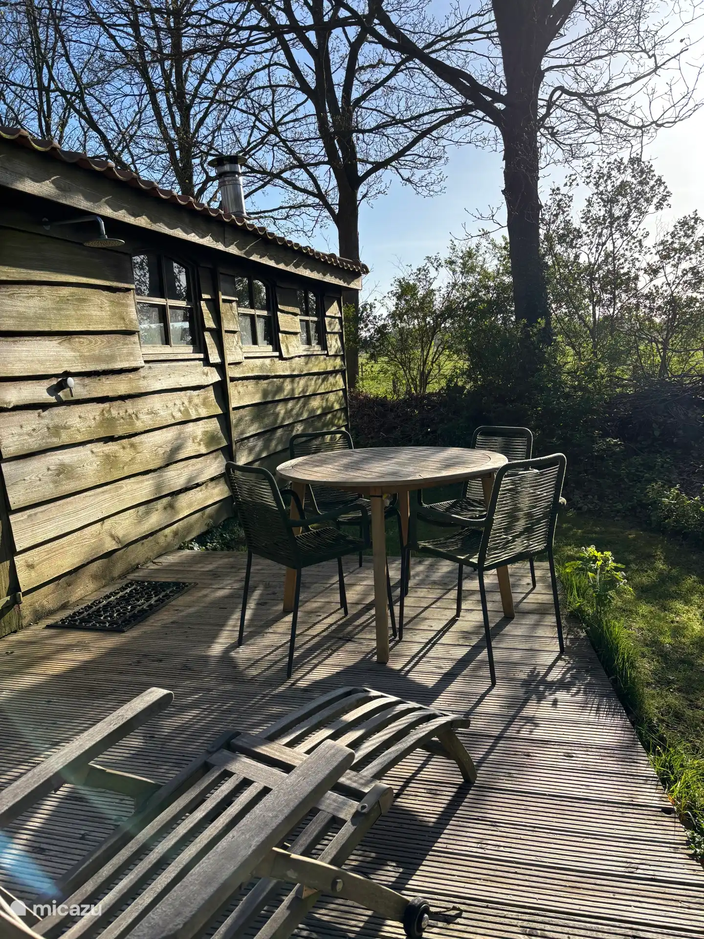 Het vlonderterras achter het tuinhuis. Nog weer zo’n plekje om lekker te genieten van de omgeving.