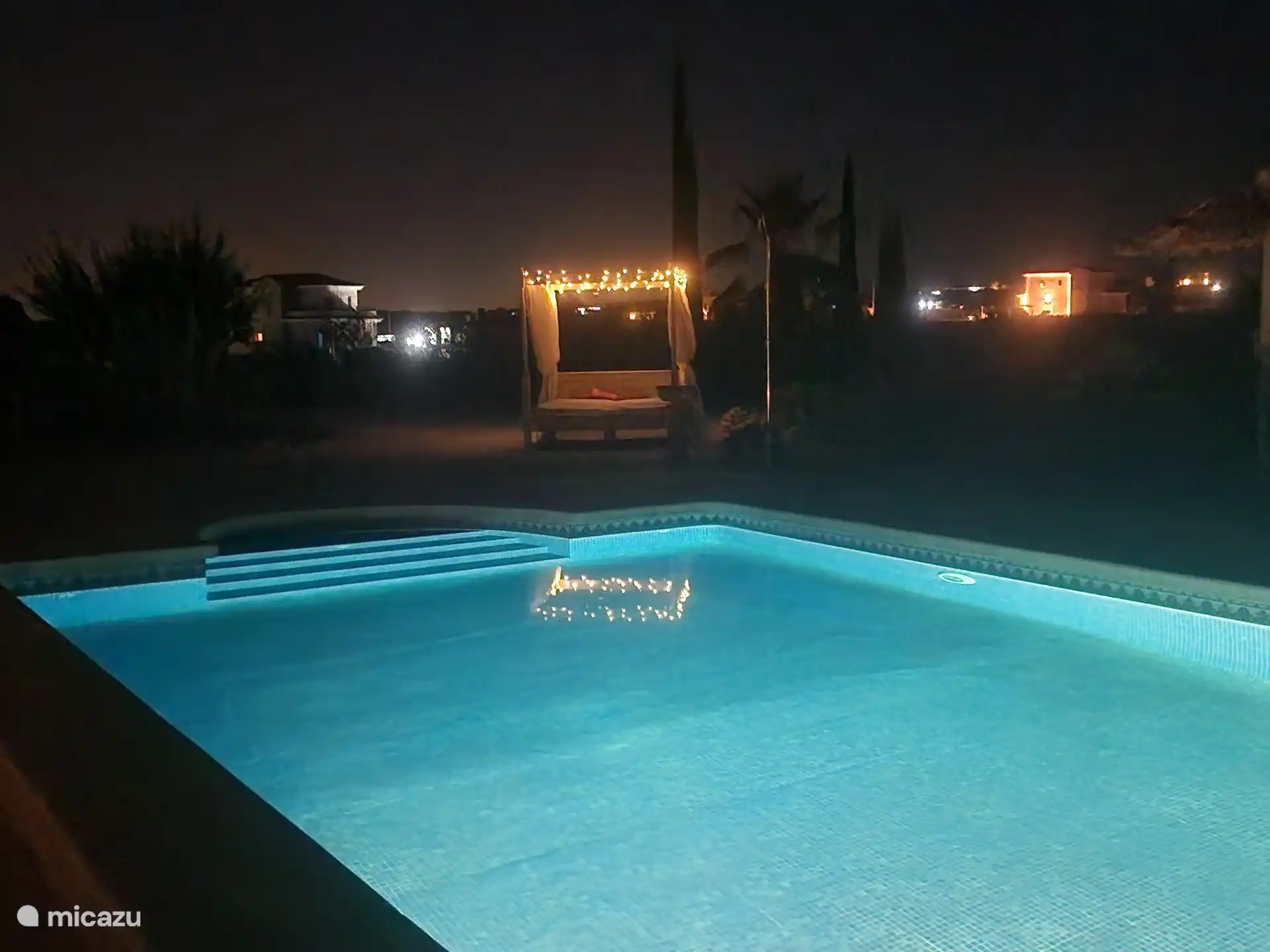 Schwimmbad mit Himmelbett im Hintergrund 