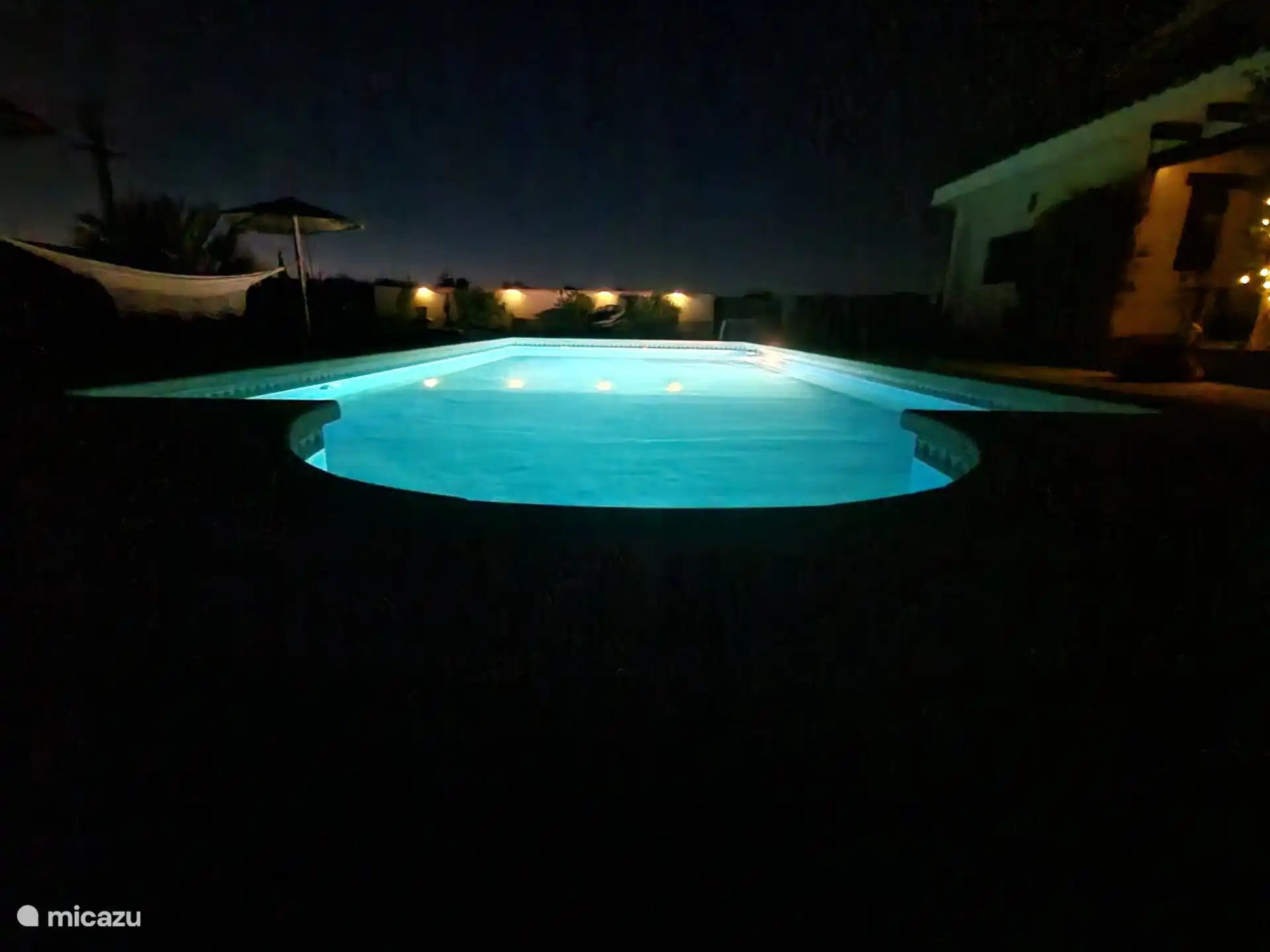 Schwimmbad am Abend mit eingeschaltetem Licht