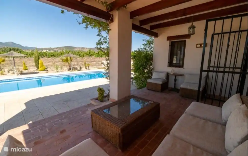 Blick auf den Pool von der überdachten Terrasse