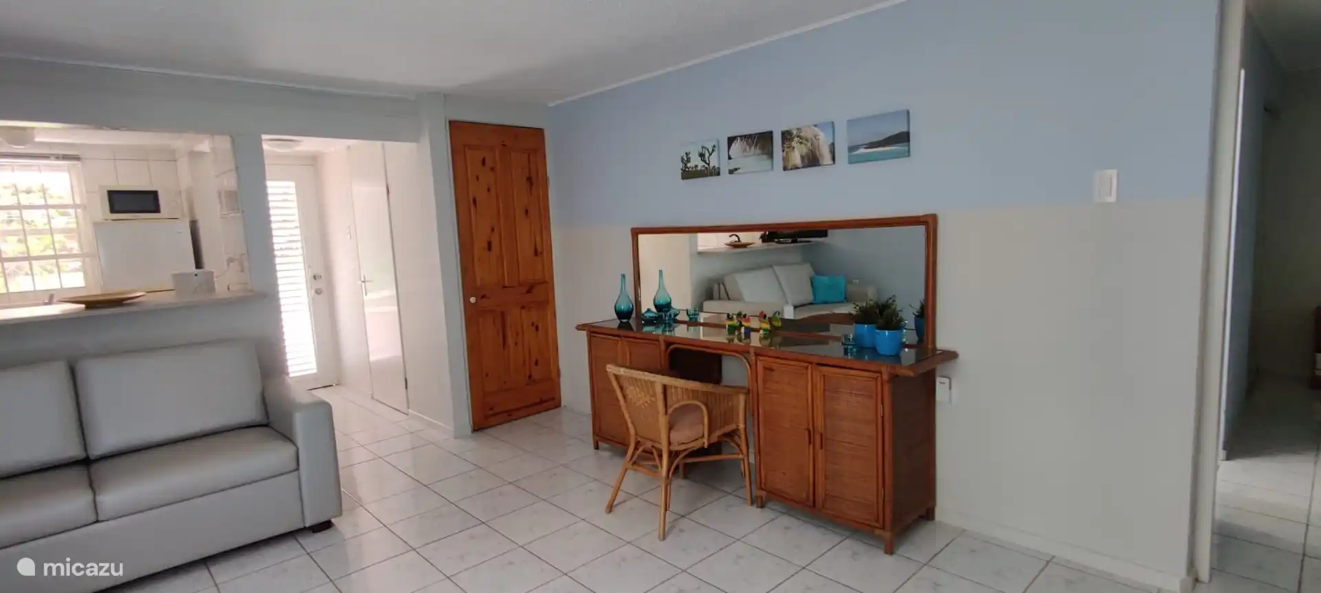 Lateral derecho salón con cómoda y armario donde está la lavadora, y detrás de la puerta del armario, que está en el recibidor hay un segundo aseo 