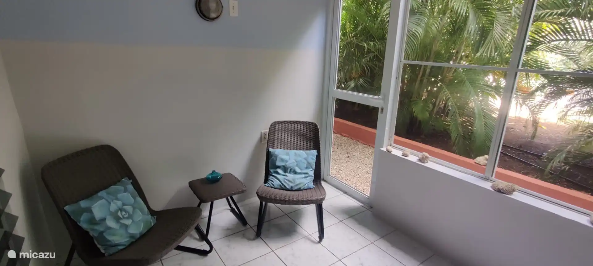 Sillas de relax en el balcón de la planta baja con ventanas de mosquitera