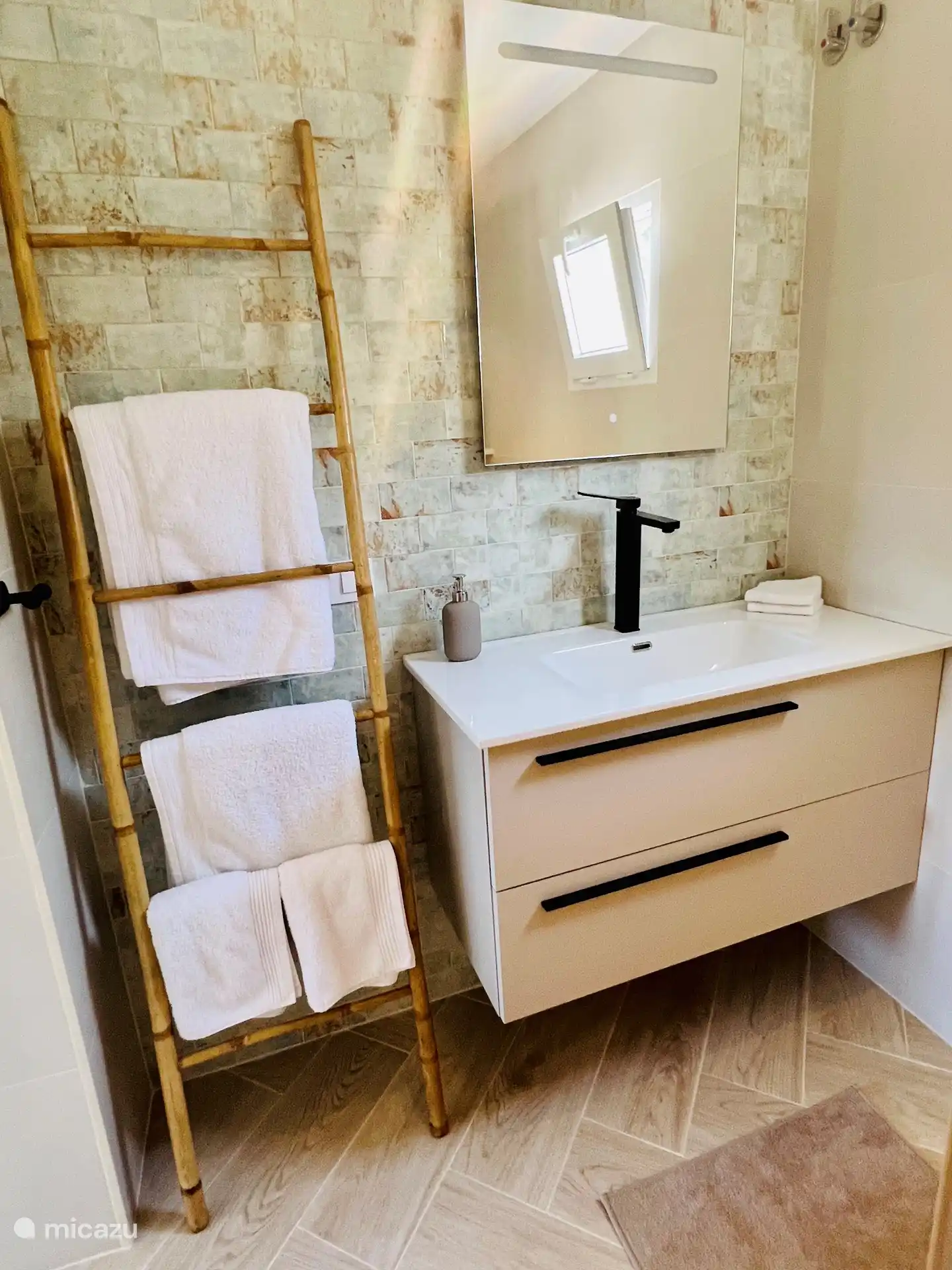 El moderno cuarto de baño en suite con lavabo grande, ducha a ras de suelo e inodoro.