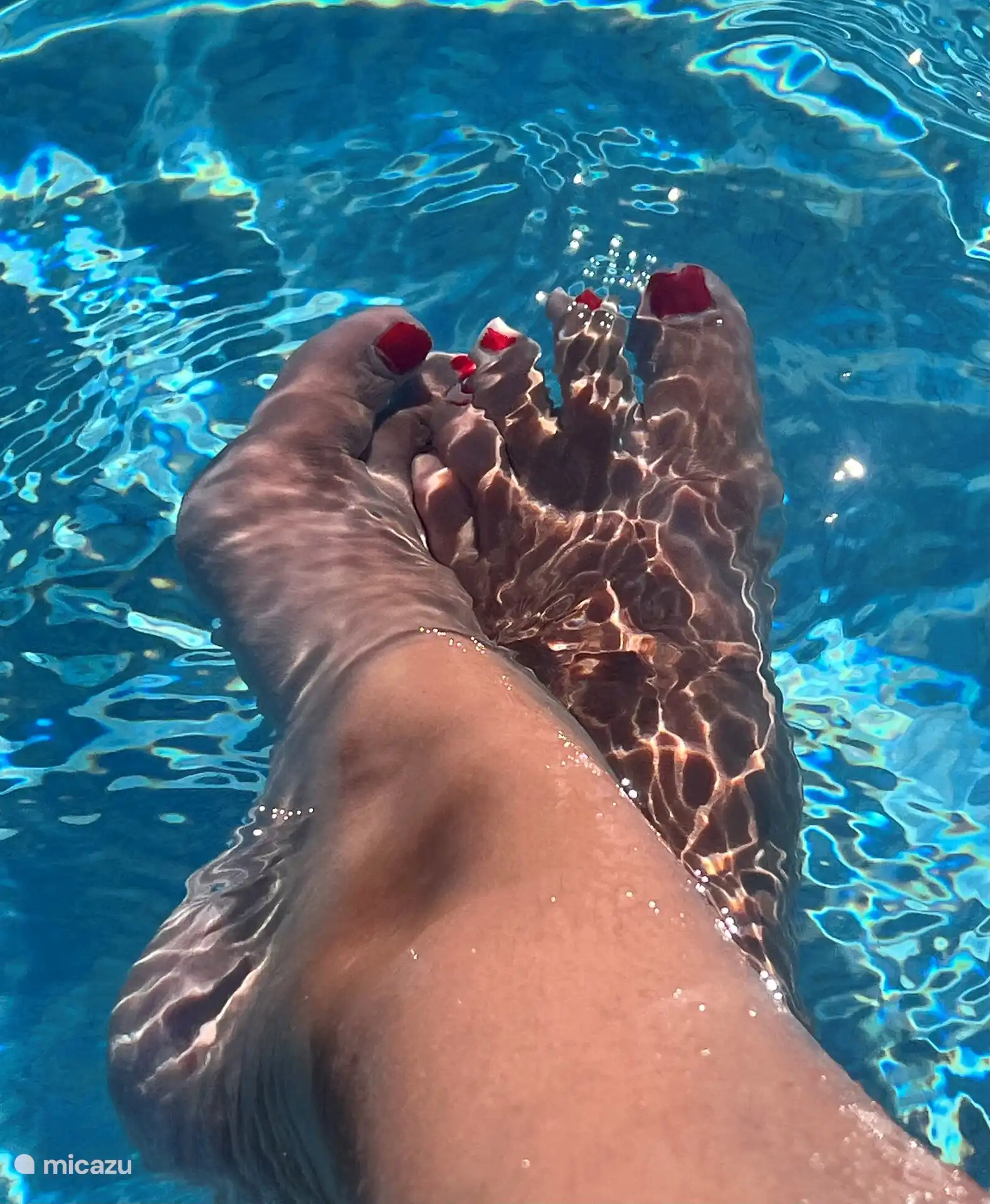 Pies en el agua de la piscina