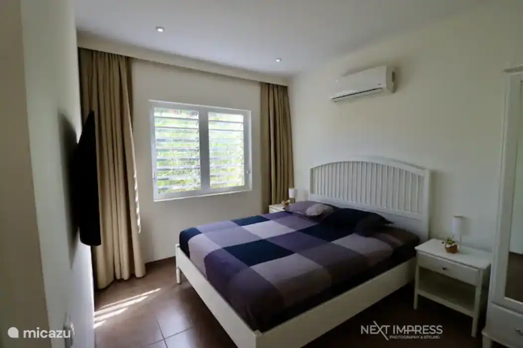 Chambre avec lit double, TV et armoire