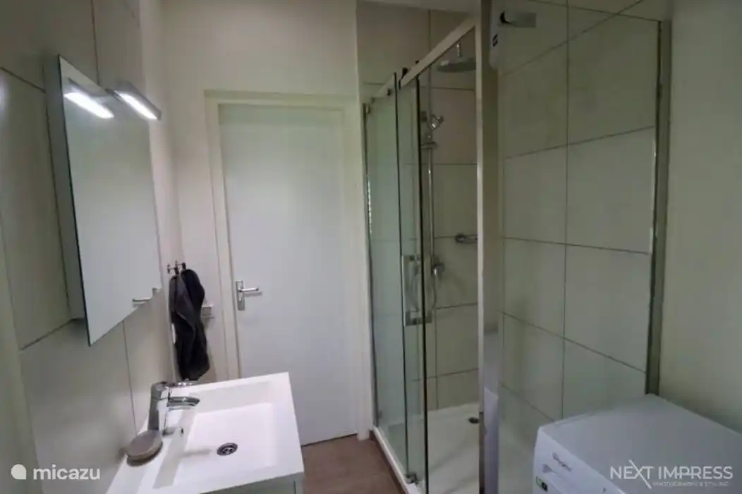 Salle de bain avec set de serviettes et machine à laver