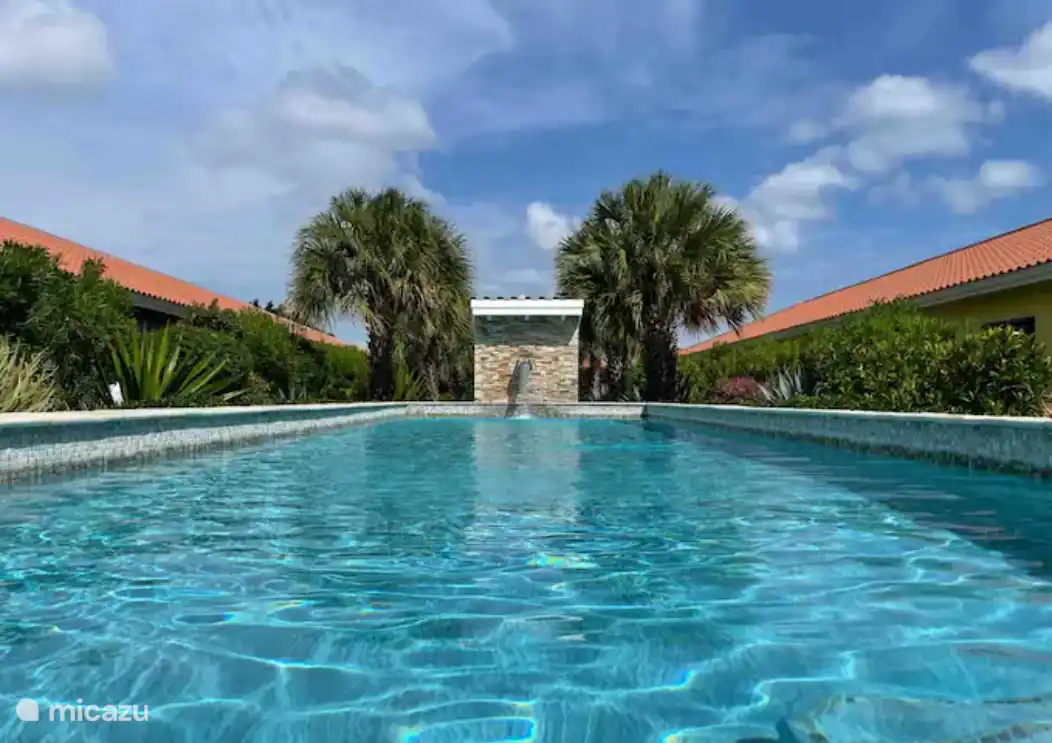 Jardin tropical avec piscine commune