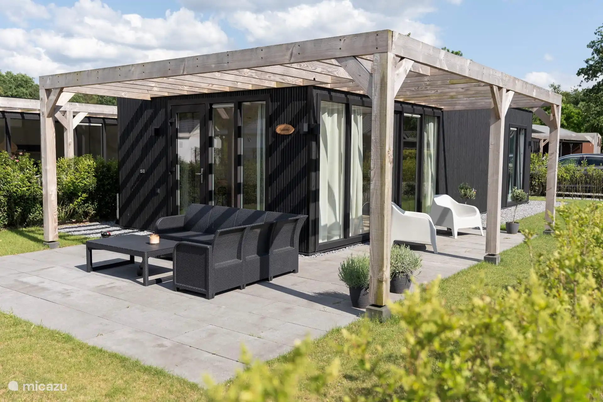 Seitenansicht des Ferienhauses mit Lounge-Set