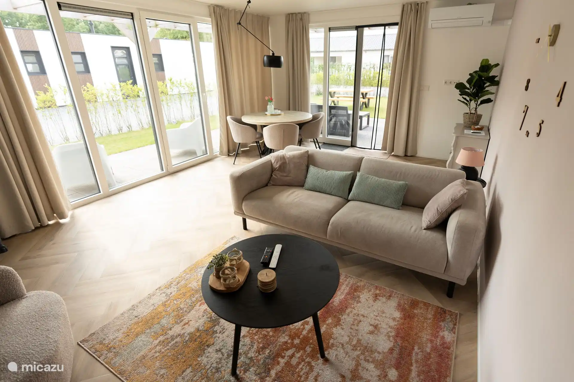 Wohnzimmer mit 2,5-Sitzer-Sofa. Esstisch mit 4 Stühlen und Klimaanlage