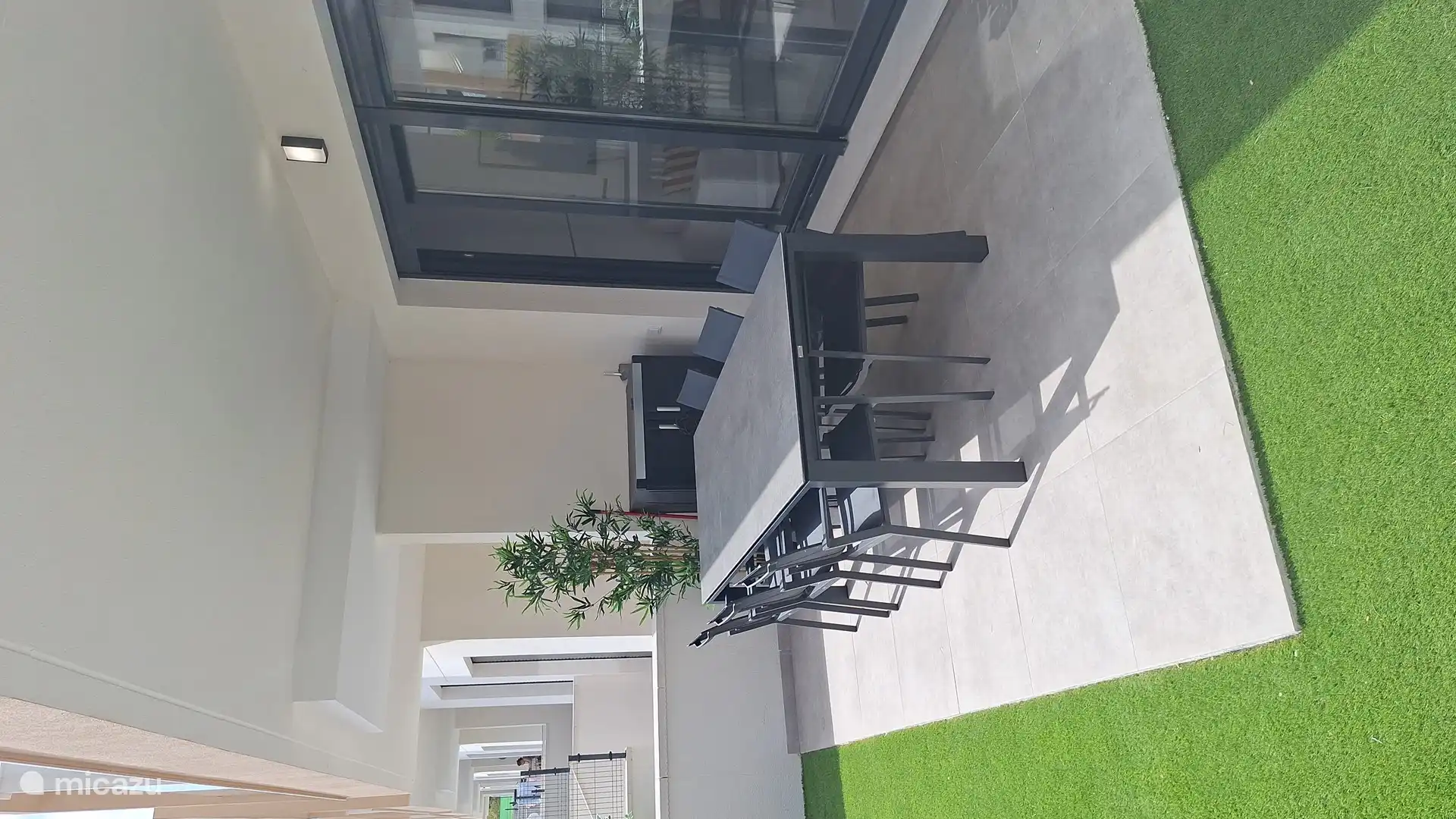 Terraza cubierta con mesa de comedor