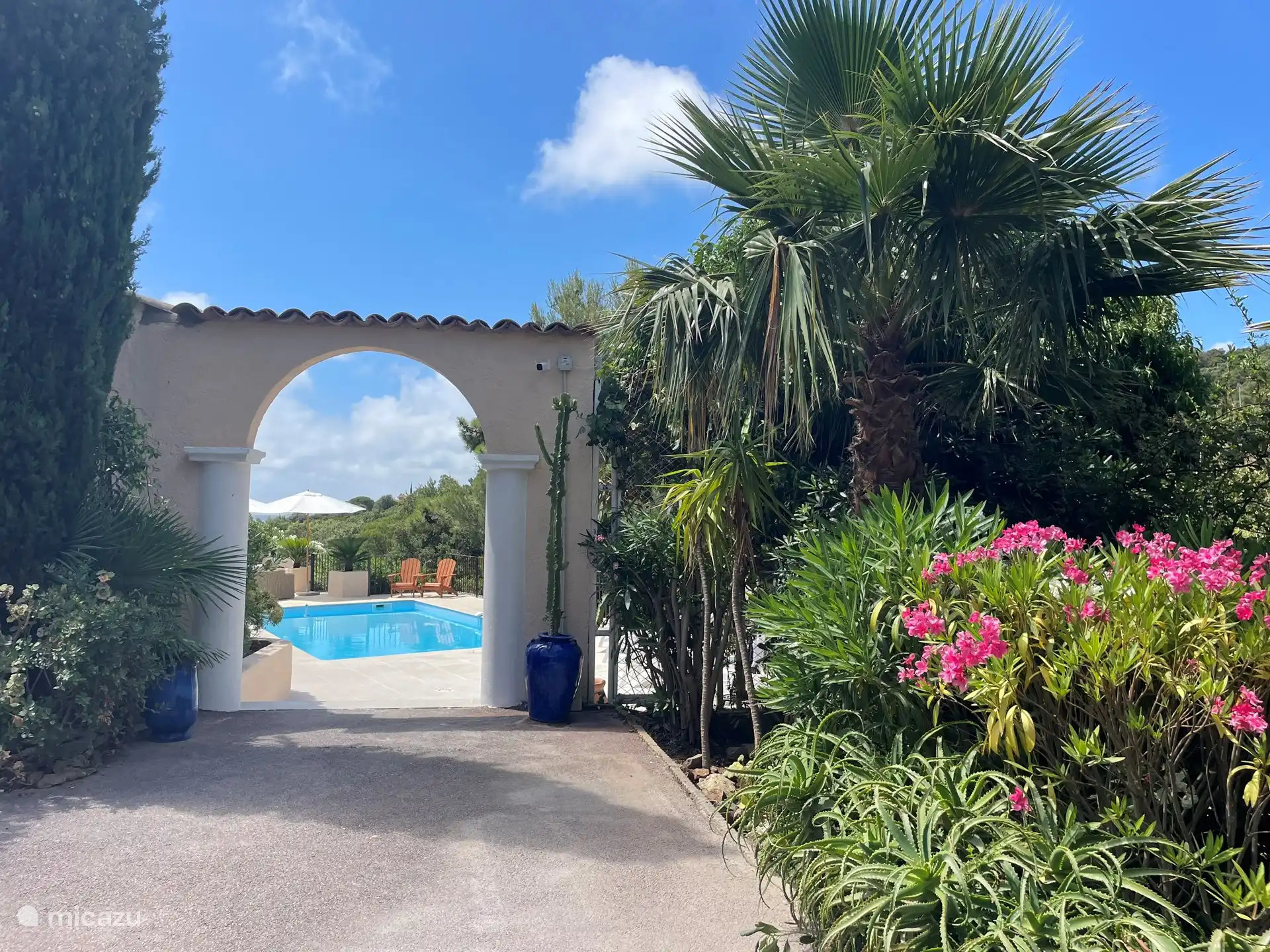 Via deze elegante boog betreed je het zonovergoten terras met prive zwembad.