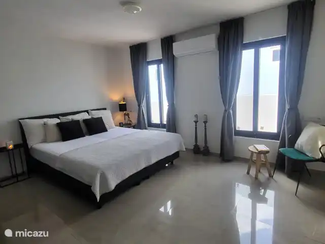 Villa Veertje  en Curazao, Bandabou (oeste), Grote Berg - casa vacacional Dormitorio principal
Grandes ventanales, mucha luz, pero también equipado con cortinas opacas, aire acondicionado, una acogedora zona de estar y una mesa de maletas.