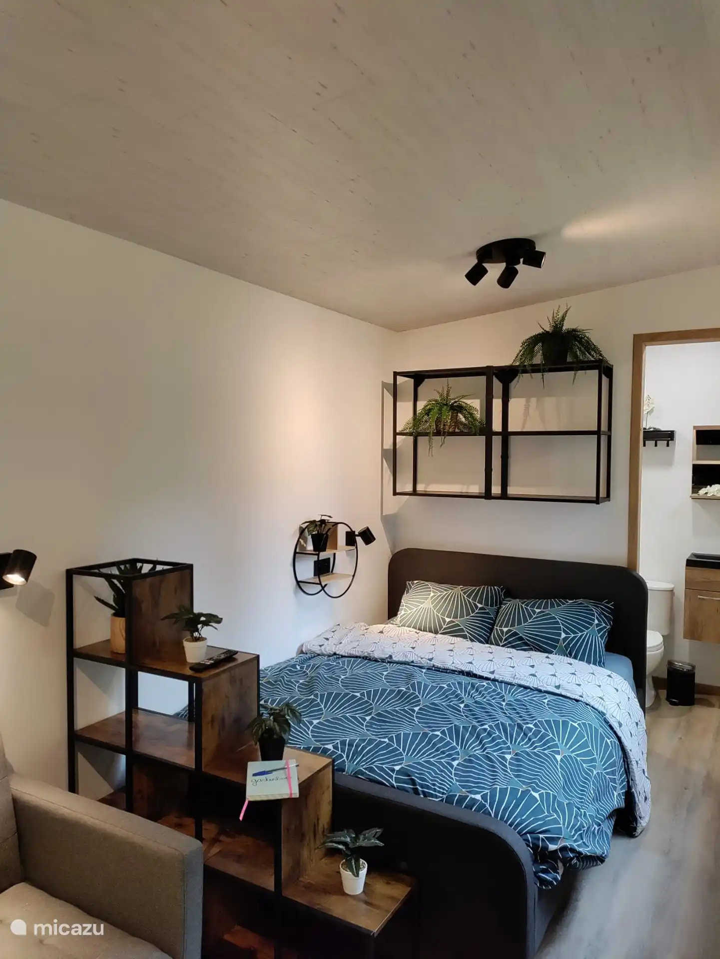 Het bed met opbergruimte bovenin in een gezellige setting.