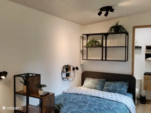 Zen huisje huren in België, Antwerpen, Turnhout - tiny house Het bed met opbergruimte bovenin in een gezellige setting.
