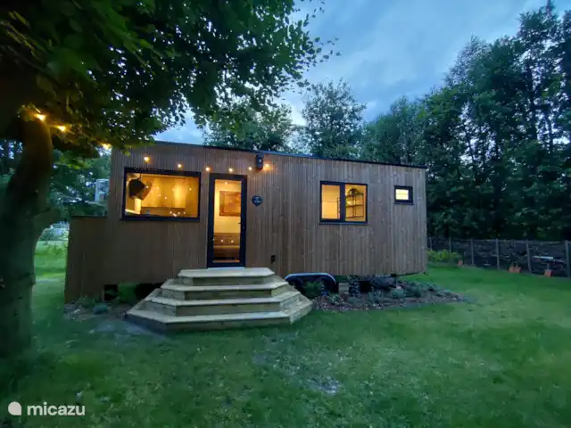 Zen huisje huren in België, Antwerpen, Turnhout - tiny house De gezellige buitenkant met een aanpalende tuin te midden van mooie bomen en een omringde takkenwal