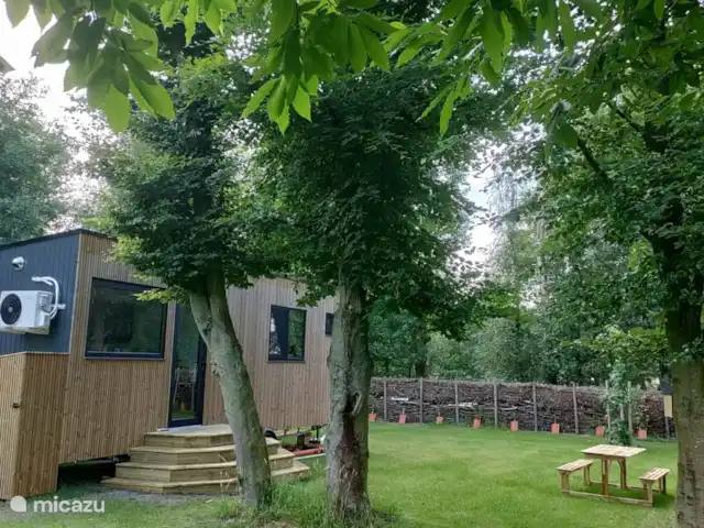 Zen huisje huren in België, Antwerpen, Turnhout - tiny house De gezellige buitenkant met een aanpalende tuin te midden van mooie bomen en een omringde takkenwal