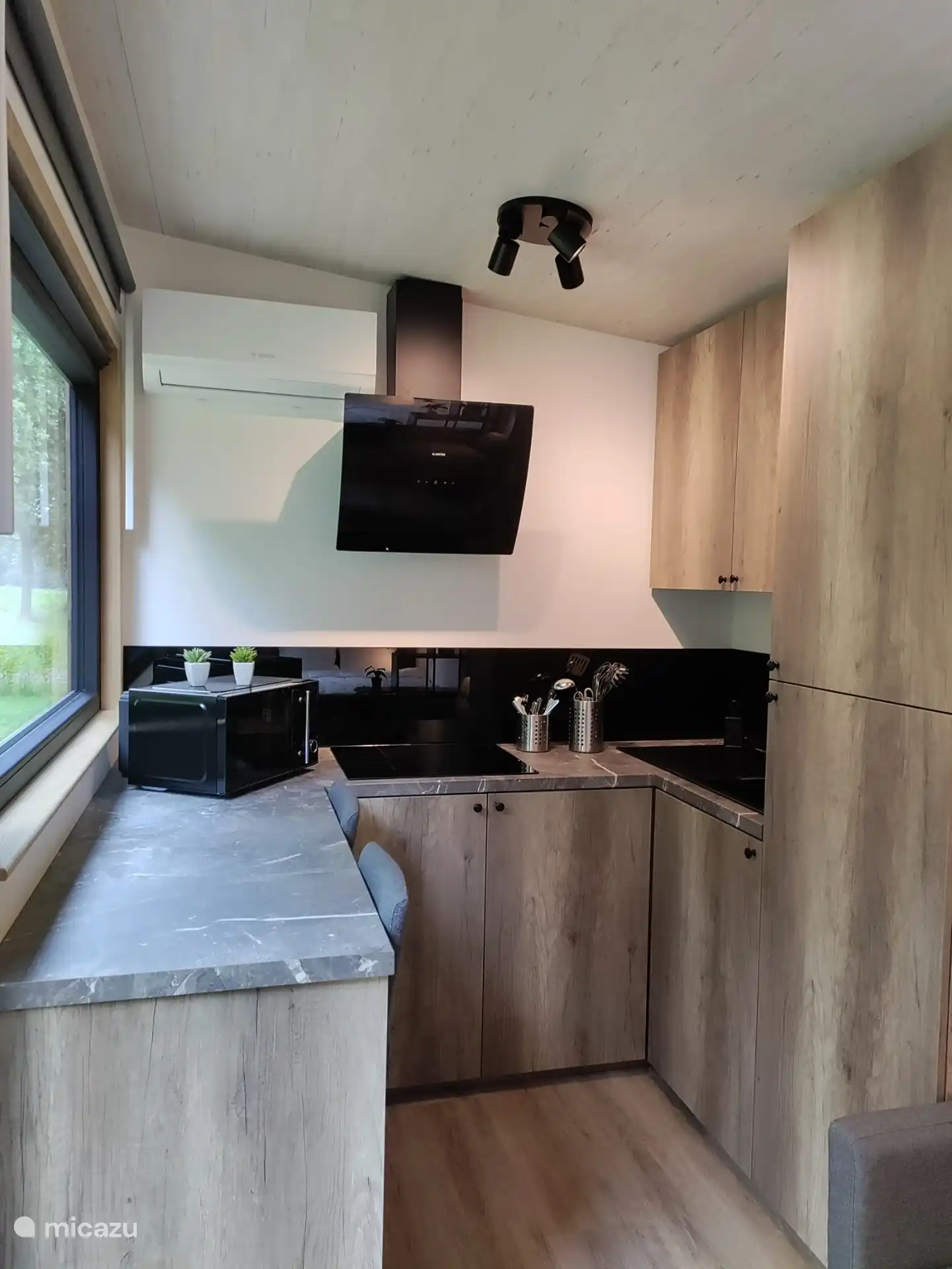 in de keuken heb je aan de linkse zijde een zitplaats voor 2 personen met een grote venster met een prachtig uitzicht op de groene omgeving en als er geen mais staat zie je tegen valavond af en toe ook hertjes uit de bossen omliggen tevoorschijn komen.