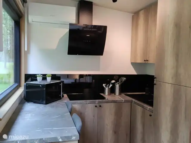 Zen huisje huren in België, Antwerpen, Turnhout - tiny house in de keuken heb je aan de linkse zijde een zitplaats voor 2 personen met een grote venster met een prachtig uitzicht op de groene omgeving en als er geen mais staat zie je tegen valavond af en toe ook hertjes uit de bossen omliggen tevoorschijn komen.