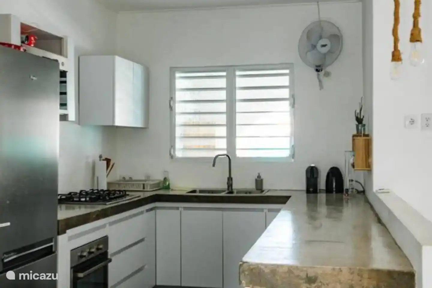 Fully equipped kitchen with dishwasher, oven, microwave, large stove, Nespresso machine and kettle.