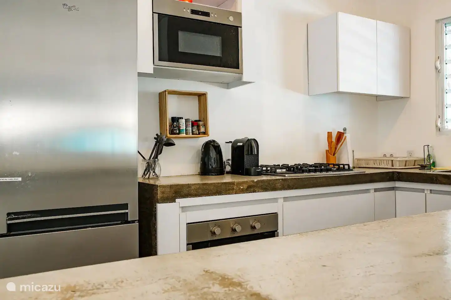 Fully equipped kitchen with dishwasher, oven, microwave, large stove, Nespresso machine and kettle.