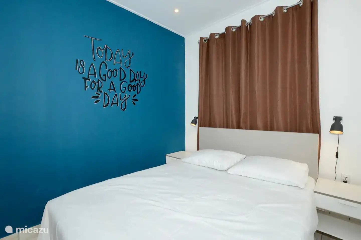 Bedroom 2 including air conditioning, fan, wardrobe and comfortable double box spring bed.