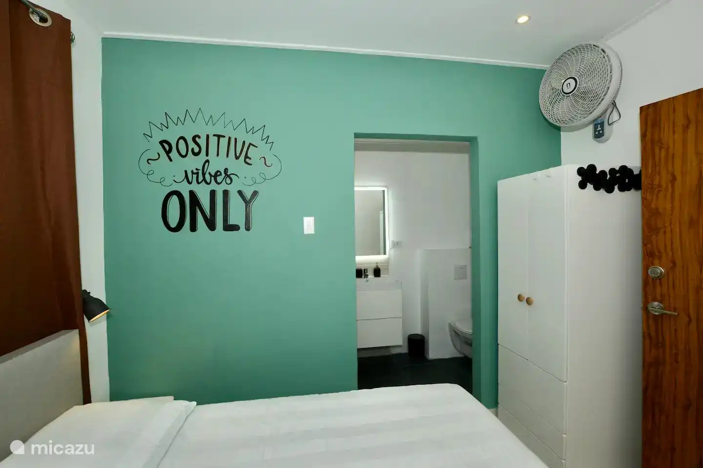 Bedroom 3 including air conditioning, fan, wardrobe and comfortable double box spring bed, with 'en suite' private bathroom. 