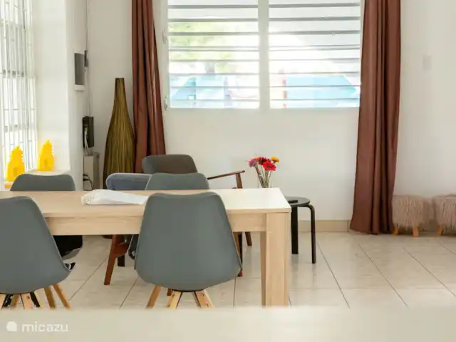 villa huren in Curaçao, Banda Ariba (oost), Marie Pampoen – Indigo House Gezellige woonkamer met eettafel en comfortabele zithoek inclusief smart tv.