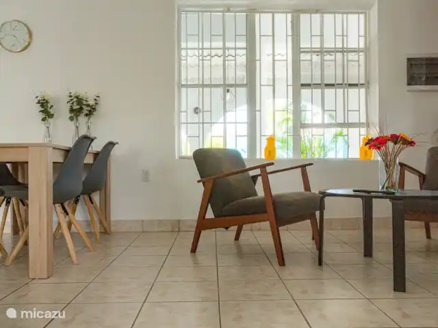 villa huren in Curaçao, Banda Ariba (oost), Marie Pampoen – Indigo House Gezellige woonkamer met eettafel en comfortabele zithoek inclusief smart tv.