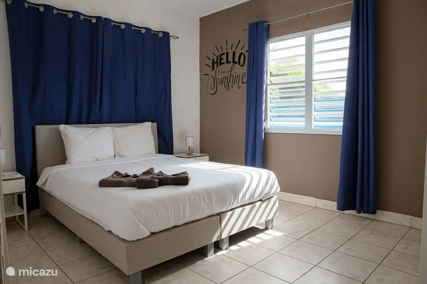 Spacious master bedroom with comfortable double box spring bed, air conditioning, fan and spacious wardrobe.