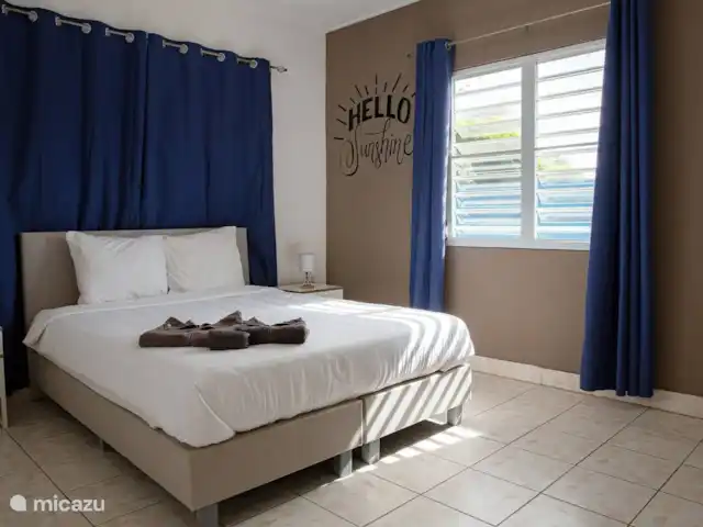villa huren in Curaçao, Banda Ariba (oost), Marie Pampoen – Indigo House Royale master bedroom met comfortabel tweepersoons boxspring bed, airco, ventilator en ruime kledingkast.
